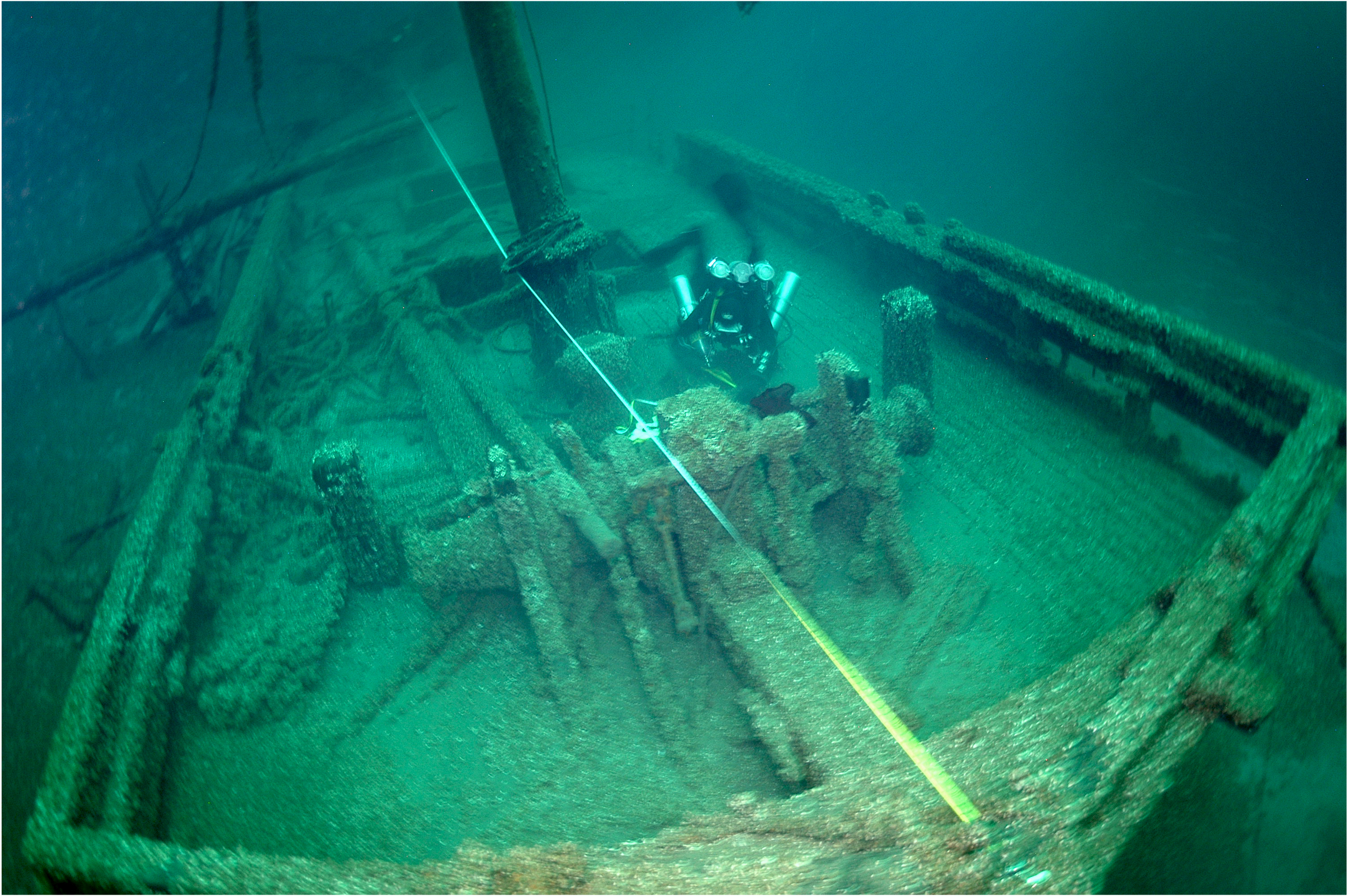A diver measures the wreck of the Silver Lake, a double centerboard scow schooner.