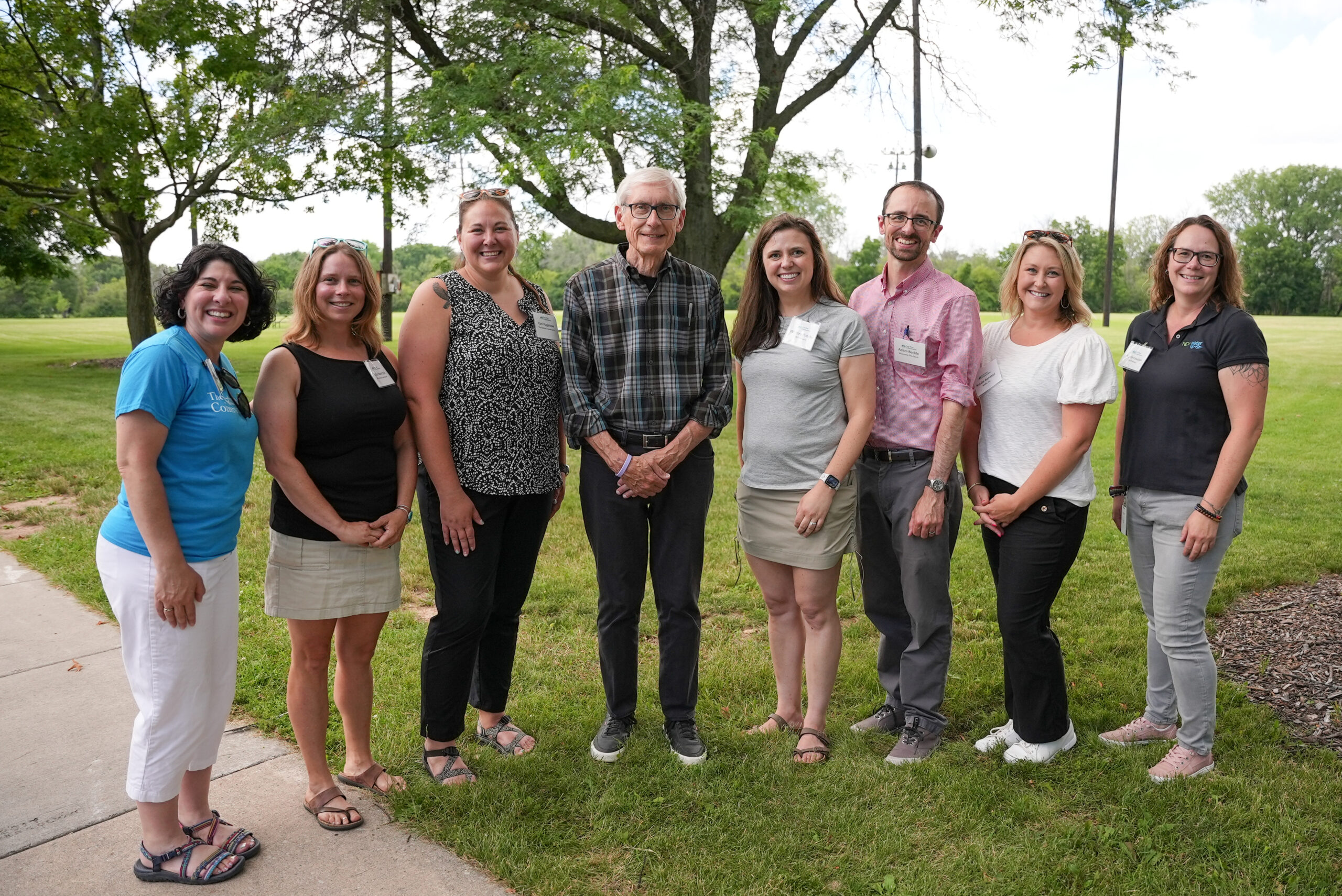 Six people of the East River Collaborative project time pose for a photo with Tony Evers.