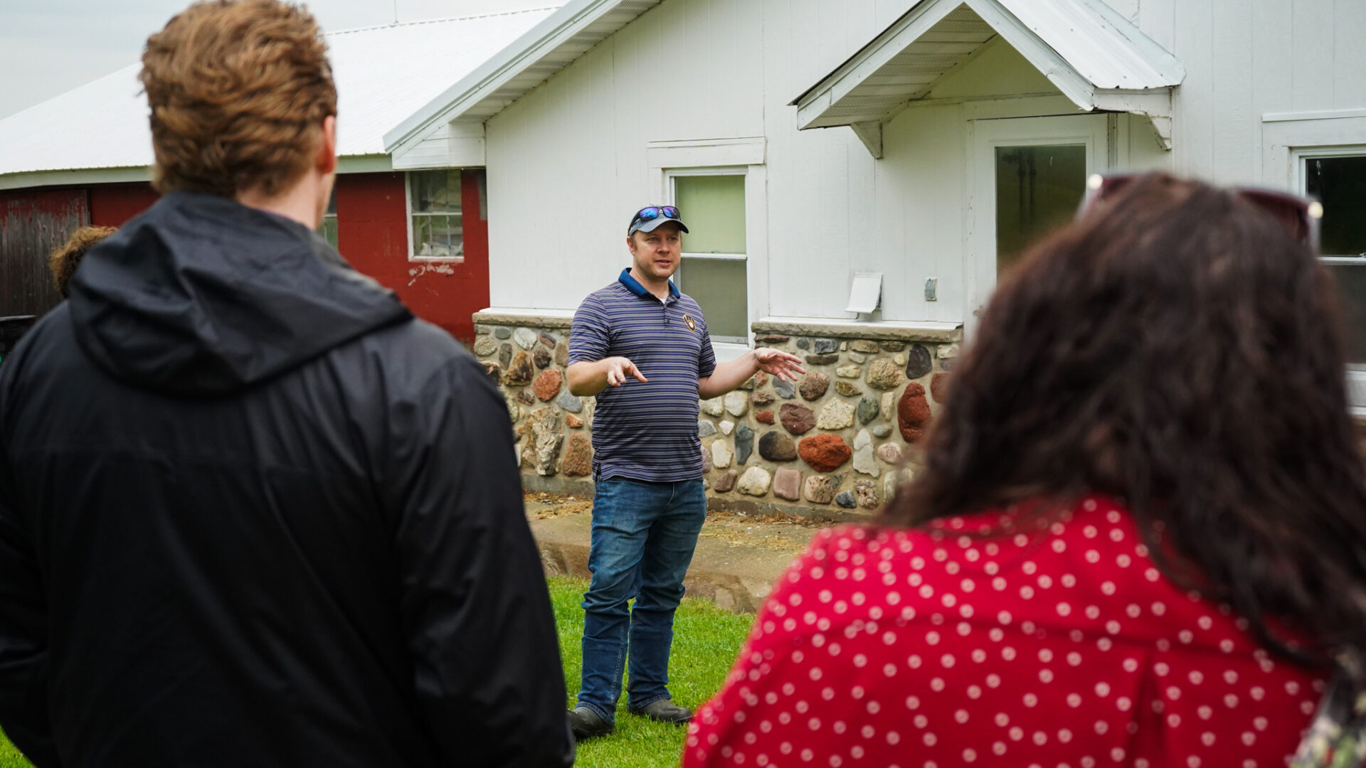 fish farmer Peter Shep stands in front of an old milking parlor building discussing aquaculture