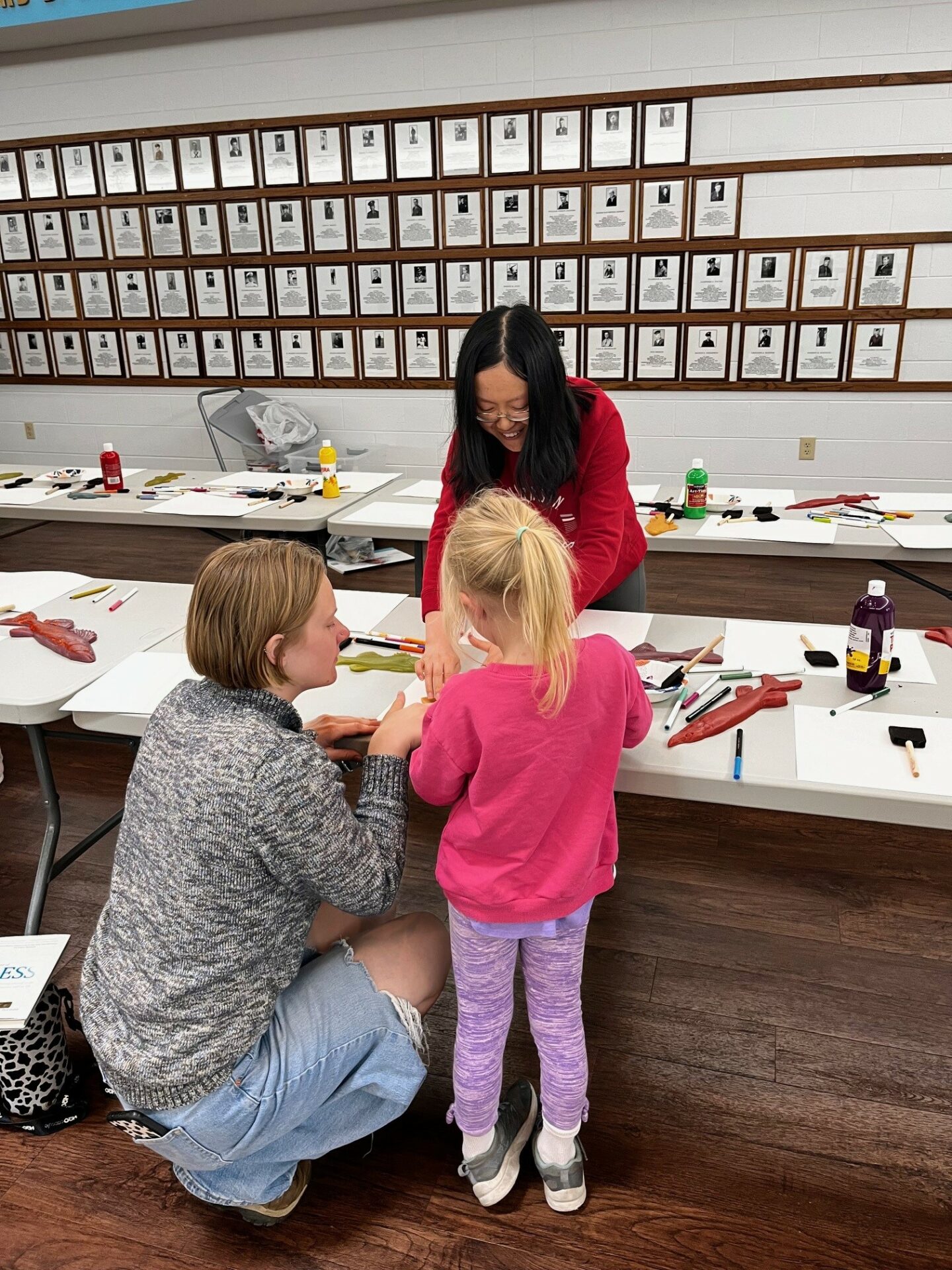 Celeste Qin helps a parent and a small child at a fish-printing event