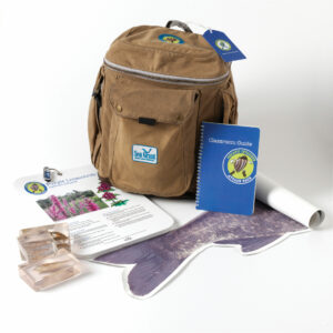 A backpack with its contents surrounding the outside of it. The contents consist of literature and equipment for the Attack Pack