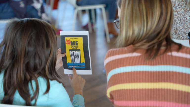 Two people looking at the Me and Debry program cover.